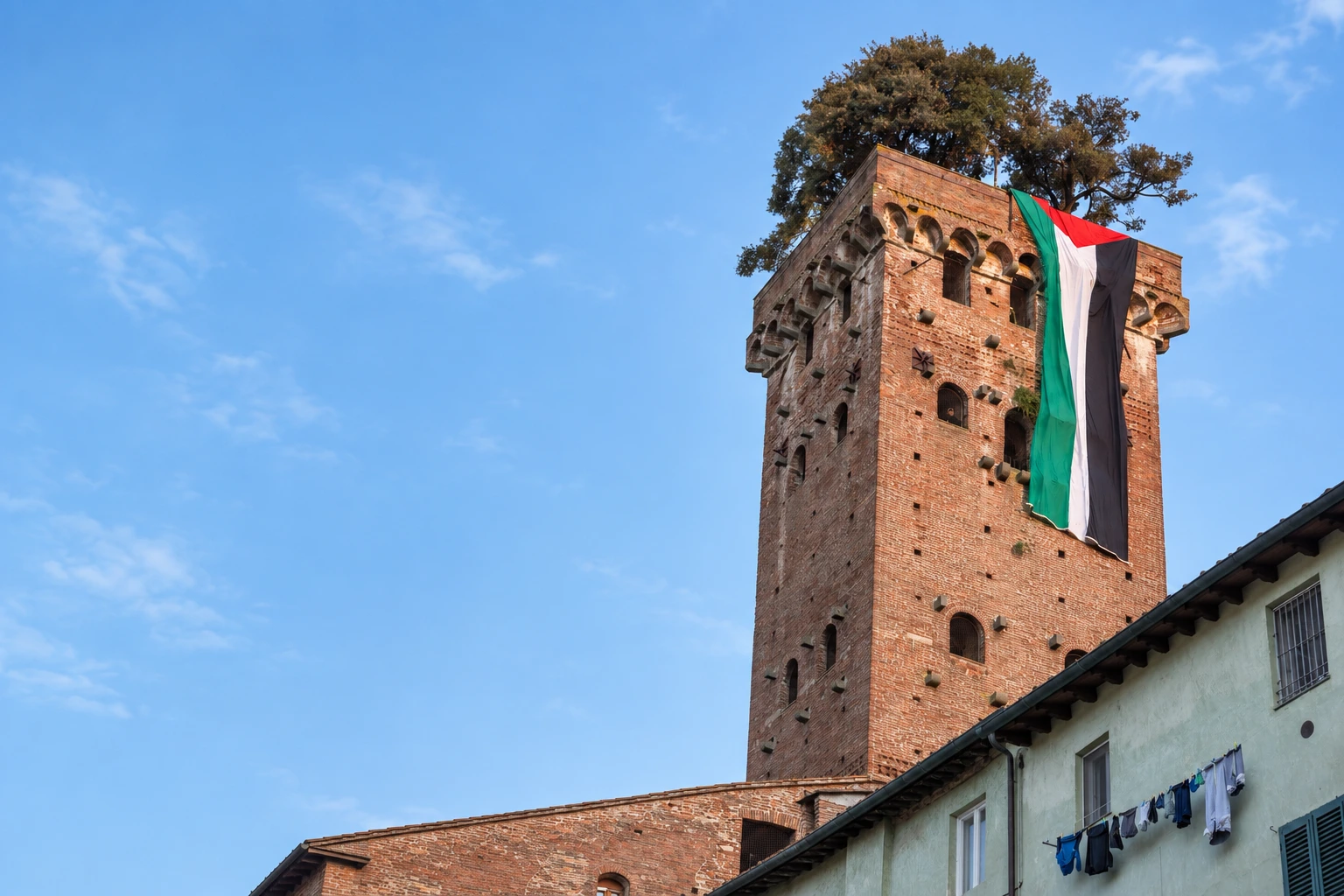 La grande bandiera palestinese appesa alla Torre Guinigi di Lucca. Fotografia rielaborata in formato orizzontale.